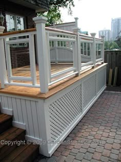 an outdoor deck with white railings and wooden steps