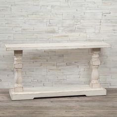 an old white wooden shelf against a brick wall with wood flooring in the background