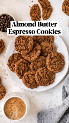 a white plate topped with cookies next to two cups of coffee