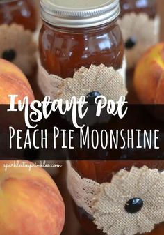 jars filled with peach pie moonsshine sitting on top of a table next to apples