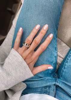 a woman's hand with two rings on her fingers, sitting on the back of a car seat