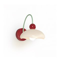 a red and white wall light with two cherries on the top of each lamp