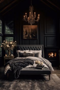 a bedroom with black walls, a chandelier and a bed in the middle