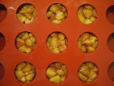 several pieces of fruit are placed in a muffin tin with holes on the side