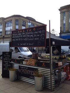 an outdoor food stand in front of some buildings