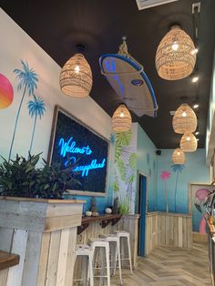 the inside of a restaurant with palm trees on the wall and lights hanging from the ceiling