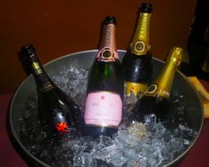 three bottles of champagne are in an ice bucket