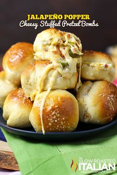 several rolls covered in cheese on a black plate