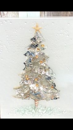 a card with a christmas tree made out of tinsel and foil on the front