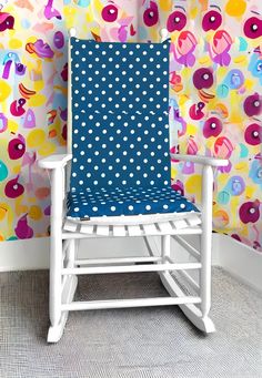 a rocking chair in front of a colorful wall with polka dots and fish on it