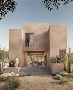 an adobe - style house in the desert surrounded by cacti and succulents