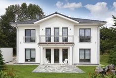 a large white house sitting on top of a lush green field