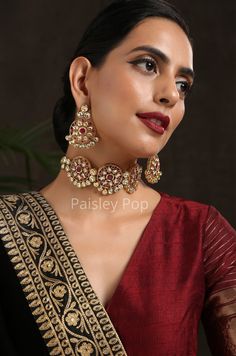 The red Kundan necklace set with is a beautiful piece of bridal jewelry designed and handcrafted by Indian artisans with traditional Indian Jewelry making techniques The lustrous beauty of the antique gold-plated choker set let you imagine the future that instills a sense of nostalgia and likely takes you down to old memories. Sabyasachi jewelry-inspired Kundan choker is an epode to the rich culture of India with its drooling little pearls having a resemblance to Bollywood Jewelry. Necklace Closure: Adjustable Dori Earrings Closure: Pushback Style Tip - This one is for all the women lovers of poetic lyricism and romanticism of the bygone era and women who want all of their selections to be a reflection of their true selves. The cascading elements in the Kundan necklace gracefully bejewel y Festive Chandbali Bridal Necklace Gift, Formal Temple Jewelry Bridal Sets With Chandbali Style, Party Bridal Sets With Meenakari In Chandbali Shape, Festive Bridal Necklace With Zari Work As Gift, Festive Bridal Necklace With Zari Work For Gift, Party Bridal Sets With Chandbali Meenakari, Hand Set Bridal Sets For Festive Party, Red Kundan Necklace With Tilla In Temple Jewelry Style, Kundan Jewelry With Zari Work For Celebrations