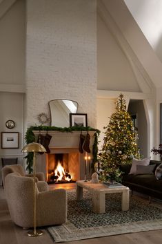 a living room filled with furniture and a fire place in front of a christmas tree