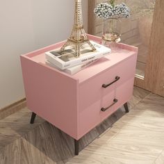 a pink nightstand with a book on it and a eiffel tower in the background