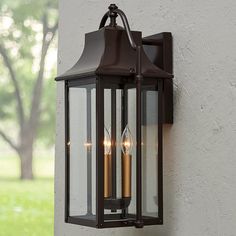 an outdoor wall light with two candles on it