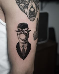 a man with a hat and mustache tattoo on his arm