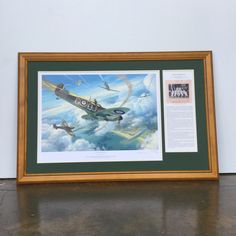 an airplane is flying in the sky with two other planes below it, framed by a wooden frame