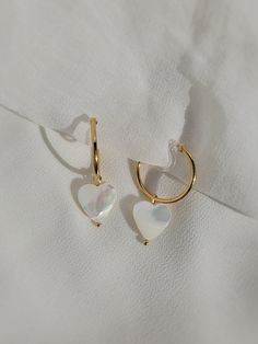 These dainty earrings are made with freshwater shell heart pearls and 18 karat gold plated hoops. This plating protects against wear and tear, tarnishing, and light contact with substances such as water. All earrings are handcrafted with care and custom made to meet your unique needs. Closure options: * Pierced closures are hypoallergenic and nickel free. * Clip on closures are made of acrylic/plastic which makes for an invisible look. They are also hypoallergenic and nickel free. How to wear clip ons: Hold the front of earring in one hand while pulling the clear closure open with the other hand, place the earring onto the thin upper earlobe, then slide the earring down the earlobe to secure in place. Please feel free to message me for any questions! Shell Heart, Freshwater Pearl Drop Earrings, Heart Hoop Earrings, Earrings Heart, Dangle Hoop Earrings, Hoop Earrings Gold, Heart Drop Earrings, Pearl Hoop Earrings, Dainty Earrings