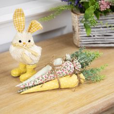 an easter bunny figurine sitting on top of a table next to some carrots