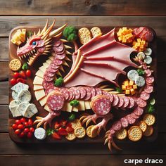 a dragon made out of cheese, crackers and meats on a cutting board