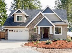 a gray house with white trim and two garages on the front, surrounded by trees