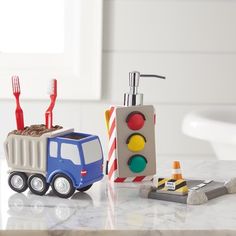 a toy truck with toothbrushes in it sitting next to a traffic light on a counter