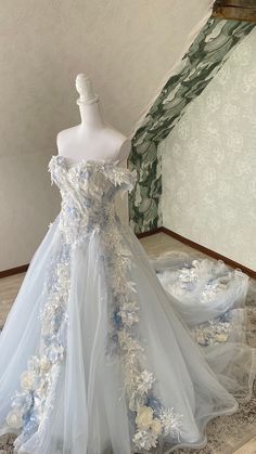 a white and blue wedding dress on display