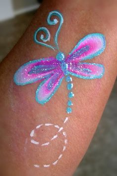 Dragonfly- Smiley Faces by Jo Small Face Paint Designs, Snail Face Paint, Face Painting Cheek Art, Cheek Art Face Paint, Basic Face Painting Designs, Cheek Art Face Paint Simple, Easy Face Painting Designs Step By Step, Face Paint Cheek Art, Easter Face Painting Ideas