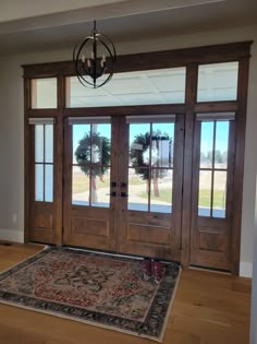 an empty room with wooden doors and rug on the floor in front of it,