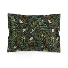 a pillow with green leaves and white flowers on it