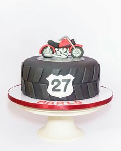 a birthday cake with a motorcycle on top and the number twenty seven in front of it