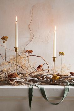 two candles are sitting on top of a mantle