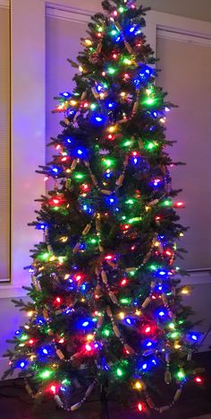 a brightly lit christmas tree in a living room