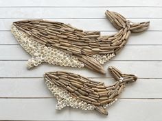 two fish made out of driftwood sitting on top of a white tile floor next to each other