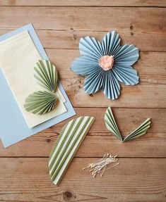 folded paper flowers and cards on a wooden table