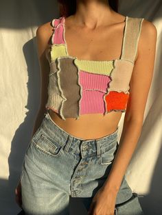 a woman with red hair is posing for the camera wearing ripped jeans and a cropped top