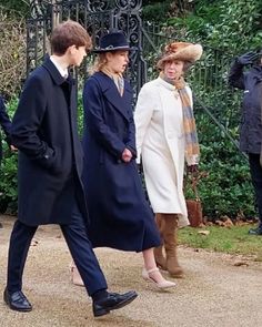 three people in coats and hats are walking together