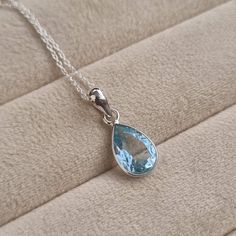 This is a simply stunning pear  shaped Blue Topaz from the gemstone rich country of Brazil.  It is available in a solid sterling silver chain of your choice, available in sizes 16,18,20,22 inches. Blue Topaz is the wedding anniversary gemstone for the 4th and is also December's birthstone. The zodiac sign for Sky Topaz is Sagittarius. Metaphysically, Blue Topaz is associated with helping people find peace instead of being overwhelmed by life. It's known as the Writers Stone because it helps to fine tune focus on immediate tasks.  Gemlogica is an American business and our motive is to create an honest and transparent company. We do not misrepresent our items and we strictly use ethically mined NATURAL gemstones and precious metals like sterling silver and gold. (we do not use brass, copper, Blue Topaz Gemstone Necklace, Classic Blue Topaz Gemstone Necklaces, Elegant Blue Topaz Birthstone Necklace Gift, Classic Blue Topaz Necklace For Gift, Classic Blue Topaz Gemstone Necklace, December Birthstone Jewelry, Clean Sterling Silver, Topaz Necklace, Unisex Necklace