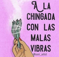 a hand holding a flower with the words la chingada con las malas vibras above it