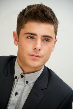 a young man in a suit and tie looking at the camera with a serious look on his face