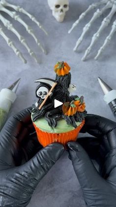 someone is decorating a cupcake for halloween