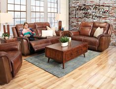 a woman sitting on top of a couch in a living room next to a coffee table