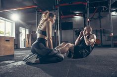 a man sitting on the ground next to a woman with her leg up in front of him