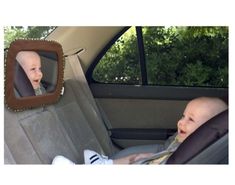 a baby in a car seat looking at another child with his head out the window