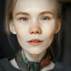 a woman with freckled hair wearing a neck tie and looking at the camera