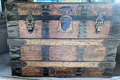 an old trunk sitting in the back seat of a car with metal latches and rivets