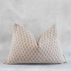 a beige and white pillow sitting on top of a bed