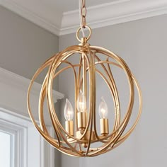 a gold chandelier with three candles in it