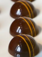 chocolates lined up in a row on top of each other with yellow stripes around them